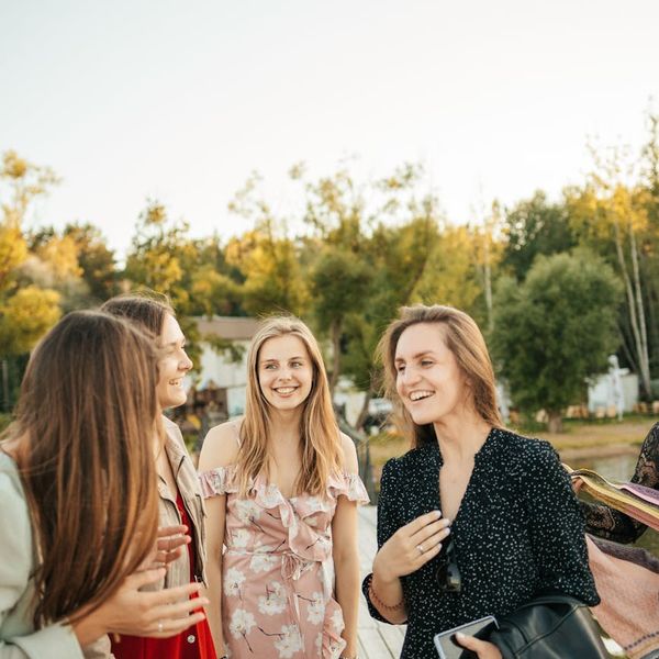 Diverse group of people smiling and looking relaxed in a nature setting.